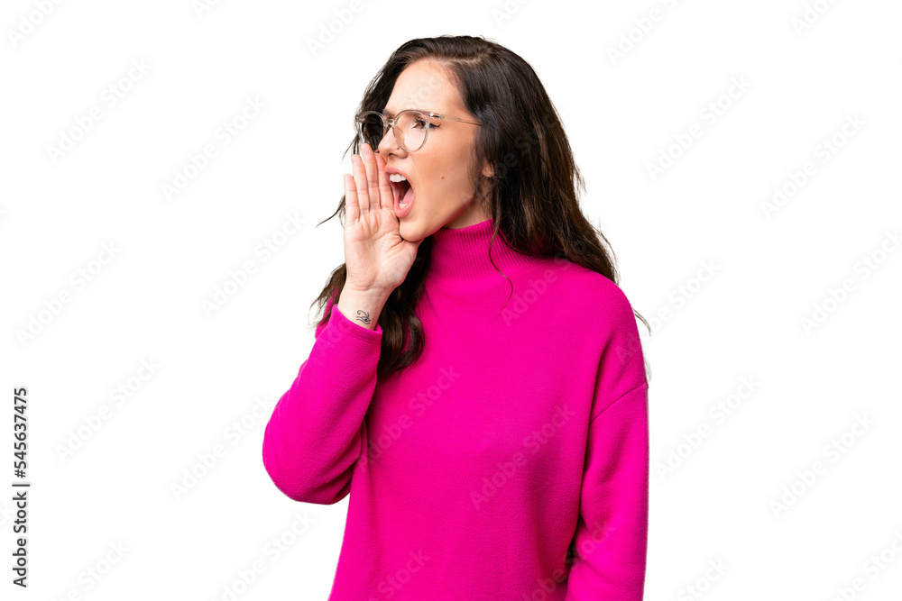 Young caucasian woman isolated over isolated background shouting with mouth wide open to the lateral Young caucasian woman isolated over isolated background shouting with mouth wide open to the lateral