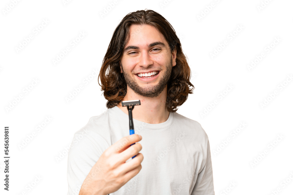 Young handsome man shaving his beard over isolated background with happy expression Young handsome man shaving his beard over isolated background with happy expression