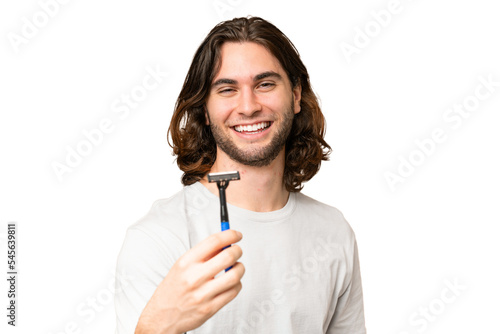 Young handsome man shaving his beard over isolated background with happy expression