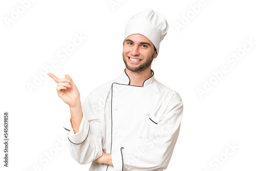 Young handsome chef man over isolated background pointing finger to the side photo