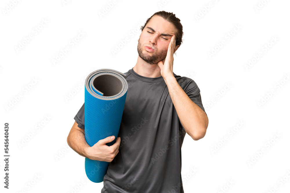 Young sport man going to yoga classes while holding a mat over isolated background with headache Young sport man going to yoga classes while holding a mat over isolated background with headache