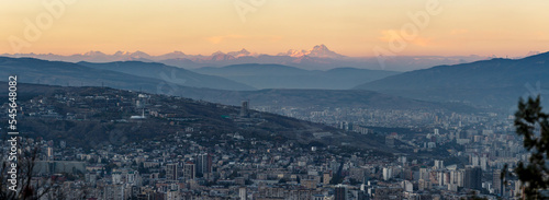 panoramic scenic aerial view of Tbilisi at dusk with Mount Kazbek on the horizon