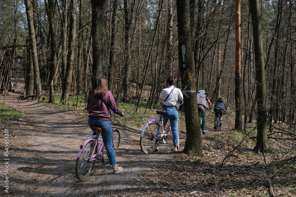 Naklejka premium Cyclists riding in a Spring forest at Holosiivskyi National Nature Park, Kyiv, Ukraine