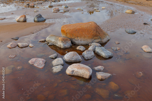 Baltic sea on a moody autumn day, view from a sandy shore with stones.