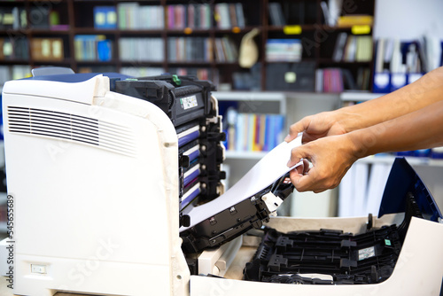 Technician hand open cover photocopier or photocopy to fix repair copier paper jam and replace ink cartridges for scanning fax or copy document in office workplace.