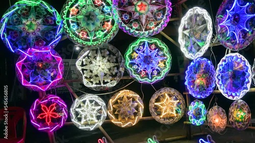 Parols for sale at a stand at nighttime. A Filipino ornamental lantern displayed during the Christmas season.