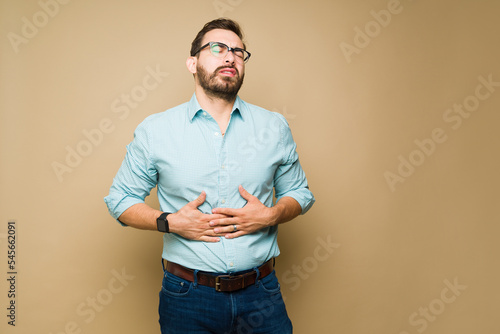 Stressed ill man with gastritis or indigestion photo