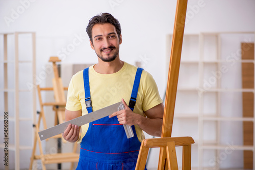 Young male repairman repairing easel at home