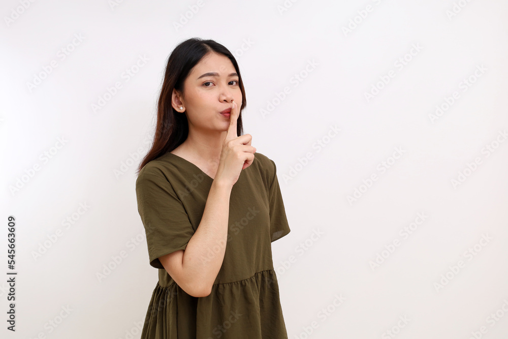 Beautiful young asian woman standing while showing telling secret or silent hand gesture. Isolated on white Beautiful young asian woman standing while showing telling secret or silent hand gesture. Isolated on white