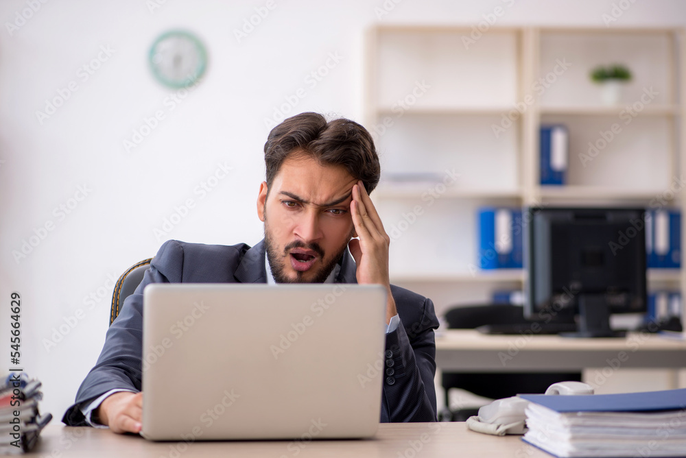 Young male employee working in the office Young male employee working in the office
