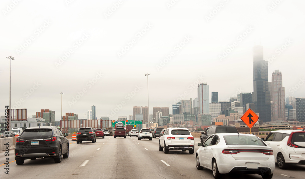 Moving traffic in a freeway or highway in Chicago with skyscrapers visible in distance
