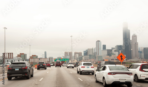 Moving traffic in a freeway or highway in Chicago with skyscrapers visible in distance