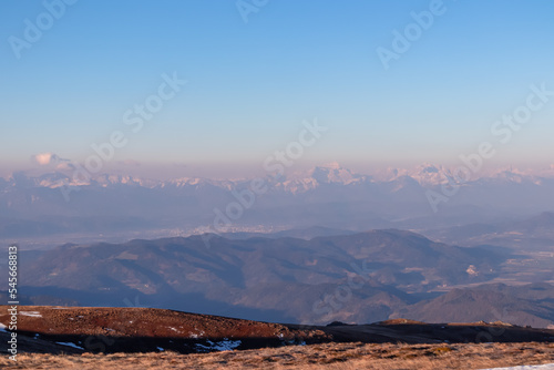 Panoramic view of the Karawanks (Karawanken) mountain range early morning after sunrise seen from Saualpe, Lavanttal Alps, Carinthia, Austria, Europe. Snowcapped mountain peaks in misty atmosphere