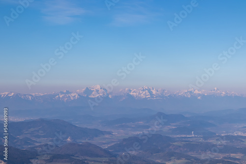 Scenic view of Karawanks (Karawanken) mountain range at early morning after sunrise seen from Saualpe, Lavanttal Alps, Carinthia, Austria, Europe. Snowcapped mountain peaks in Southern Limestone Alps photo