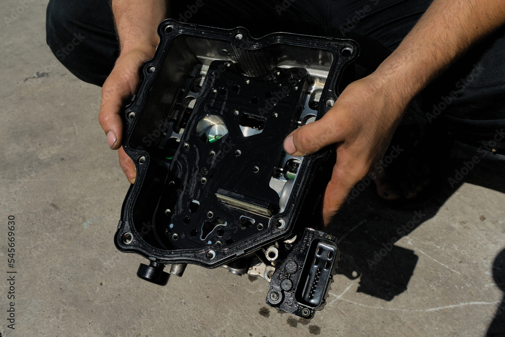 Disassembled automatic transmission from the car. DSG transmission on modern cars from the inside in the hands of an auto mechanic Disassembled automatic transmission from the car. DSG transmission on modern cars from the inside in the hands of an auto mechanic