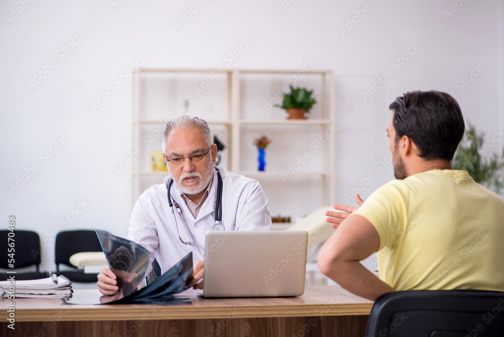 Young male doctor visiting old male doctor radiologist Young male doctor visiting old male doctor radiologist