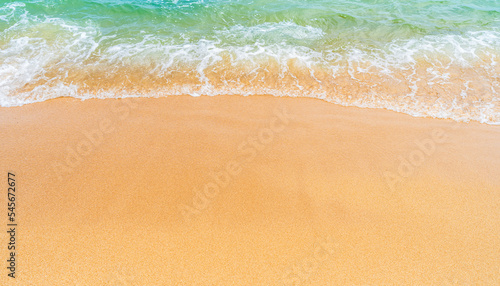 Sand beach seaside with yellow sandy and white foamy green wave from the sea on daylight well free space for text promotion with tourists or travel in summer tropical 