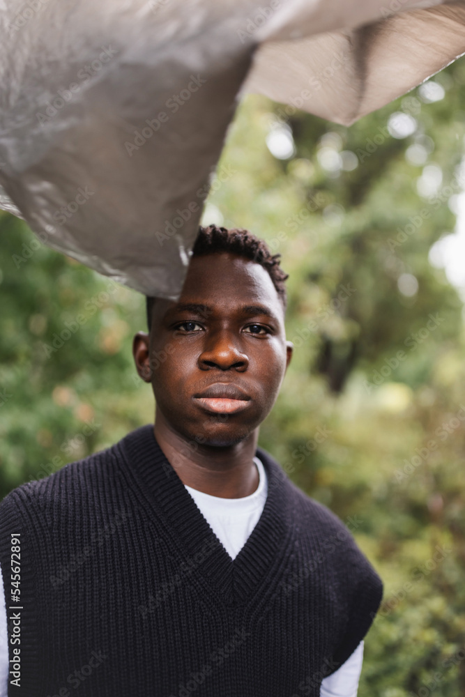 Young African man portrait. Plastic pollution, ecology concept