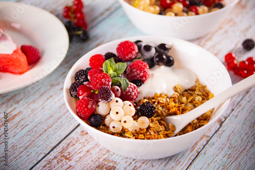 Granola, muesli cereals with yogurt or milk and fresh berries. Healthy breakfast concept.