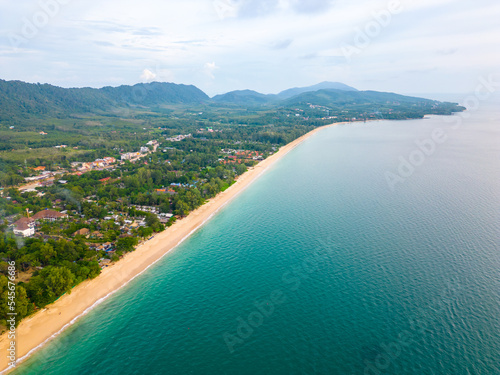 Aerial drone view of Koh Lanta island - the long beach. Famous tropical beach with white sand and turquoise ocean. The island mountains in background. photo