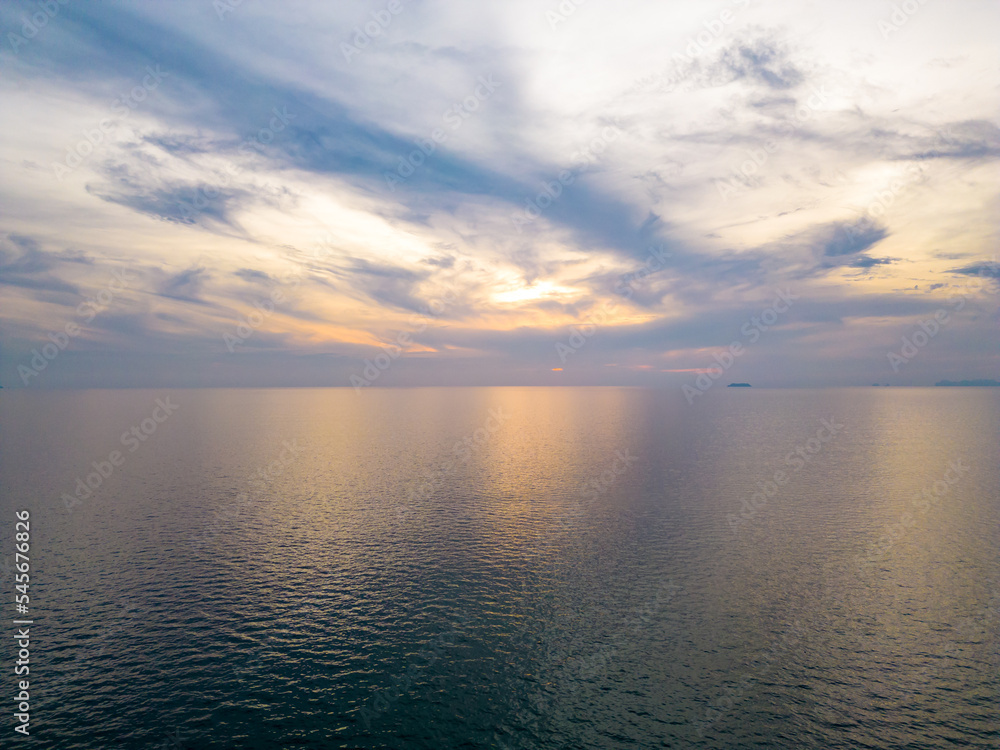 Sunset over the ocean, soft warm colors. Aerial view above ocean. Sunset over the ocean, soft warm colors. Aerial view above ocean.