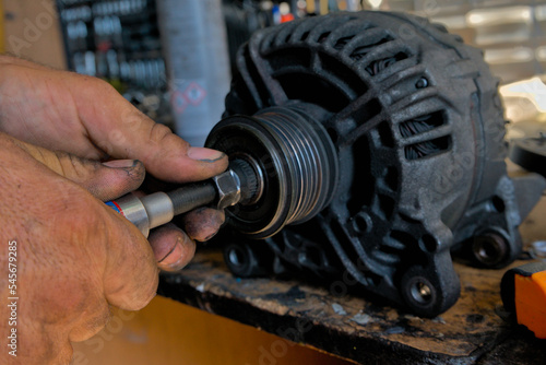 A removed car generator and its opening for diagnostics and repair at a car service.