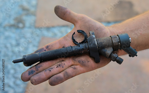 Removed old nozzle from a diesel engine on a hand