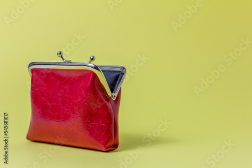 An open red coin purse on a yellow background with a space for copying. photo