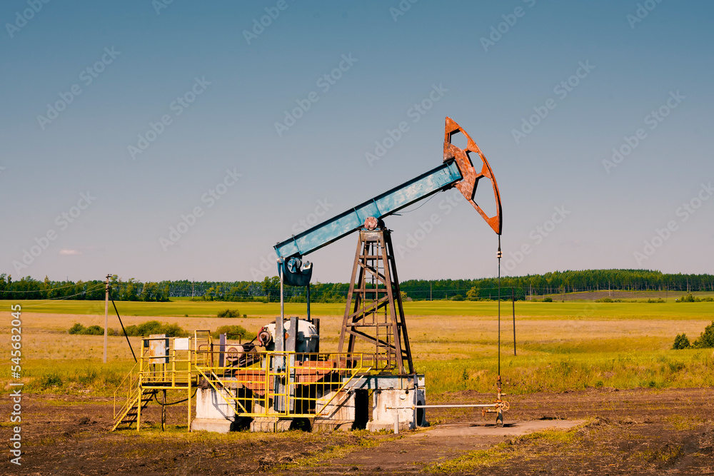 Obraz premium Oil pump jack under the blue sky with summer working. Oil rig energy industrial machine.
