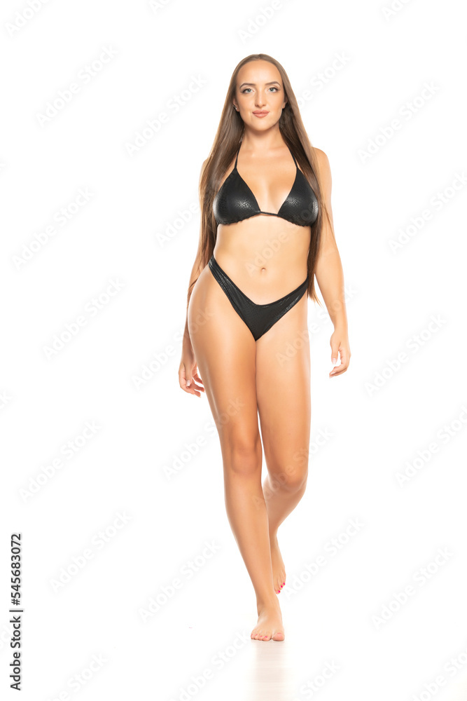 Beautiful young woman in black bikini on a white background. Front view Beautiful young woman in black bikini on a white background. Front view