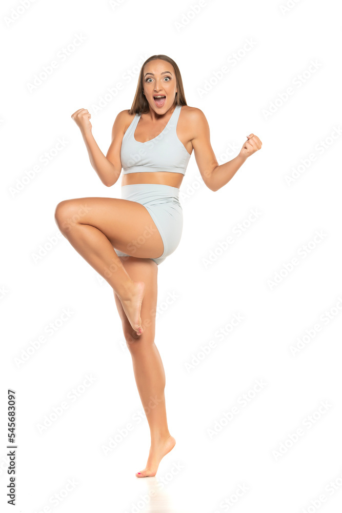 young happy barefoot sports woman with long hair in a shorts and top on a white background young happy barefoot sports woman with long hair in a shorts and top on a white background