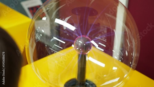 People touch the plasma ball causing sparks of energy at the museum of sciences