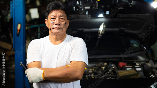 Portrait senior asian male mechanic engineering working on Vehicle in a Car Service. Repair specialist, technical maintenance. Small business owner.