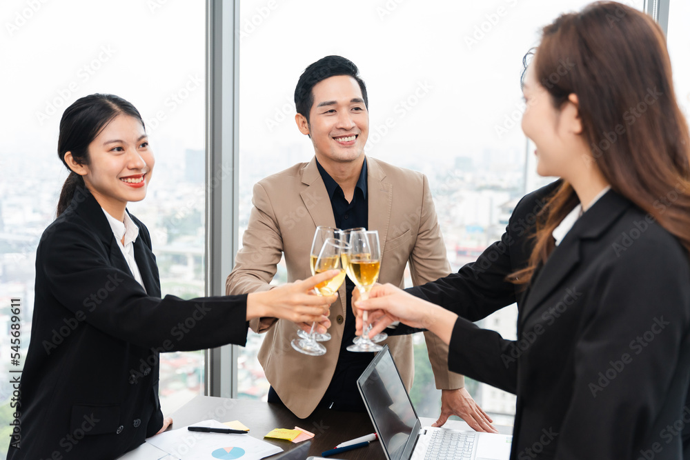 group of Asian business people holding glasses of wine to celebrate new year