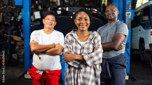 Group portrait 3 people. Mechanic car garage woner customer and mechanical car service and repair. Unity professional teamwork concept. photo