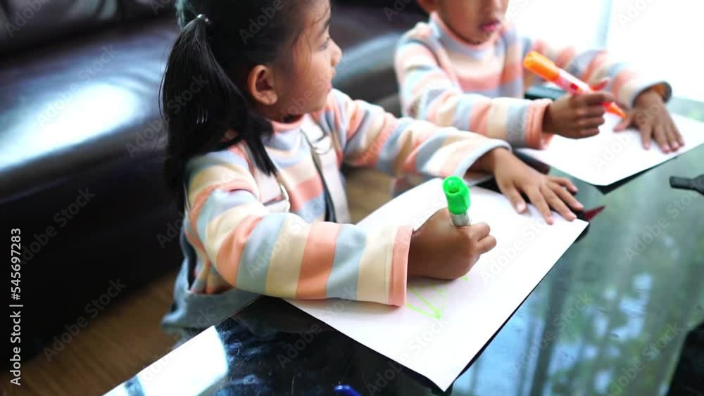 Asian child student video conference e-learning with teacher and classmates on computer in living room at home