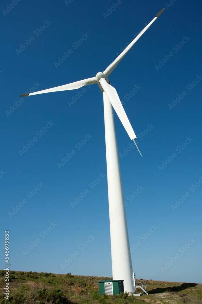 Low angle of a windmill turbine against a blue sky Low angle of a windmill turbine against a blue sky
