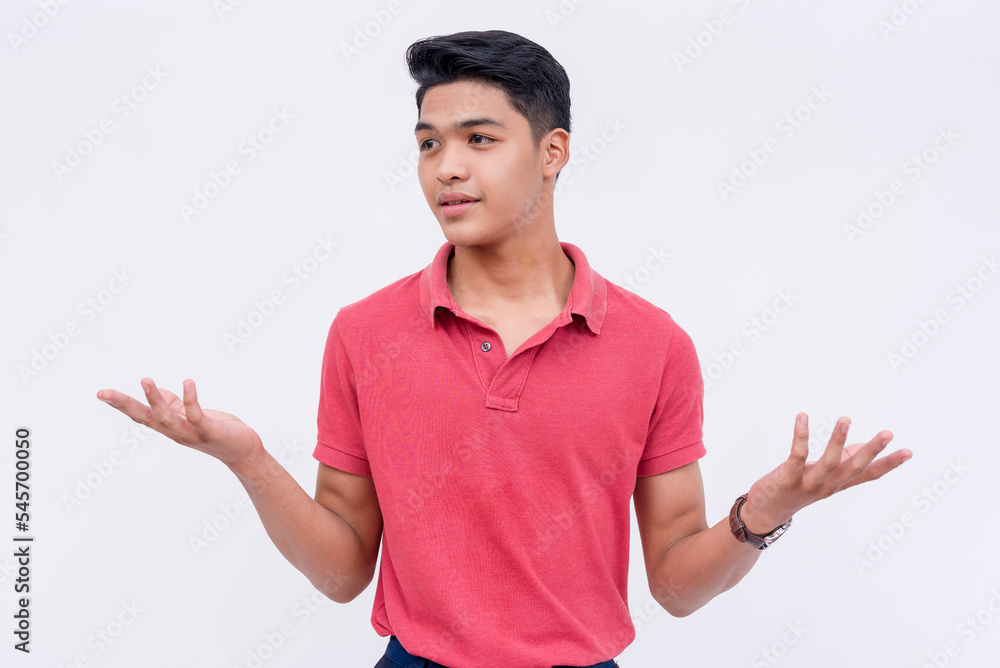 A cocky young asian man shrugs, claiming not to know what to do while looking aloof and arrogant. Isolated on a white background. A cocky young asian man shrugs, claiming not to know what to do while looking aloof and arrogant. Isolated on a white background.