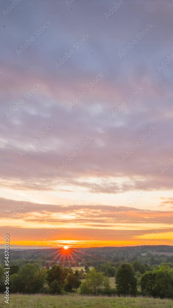 Time-lapse of a sun rising with green landscape, vertical shot Time-lapse of a sun rising with green landscape, vertical shot