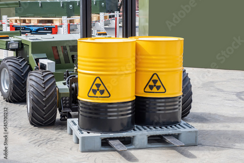 Barrels with radioactive products. Unmanned forklift. Machine for working in radioactive zone. Forklift for transportation of hazardous substances. Robot carries barrels of radioactive material photo