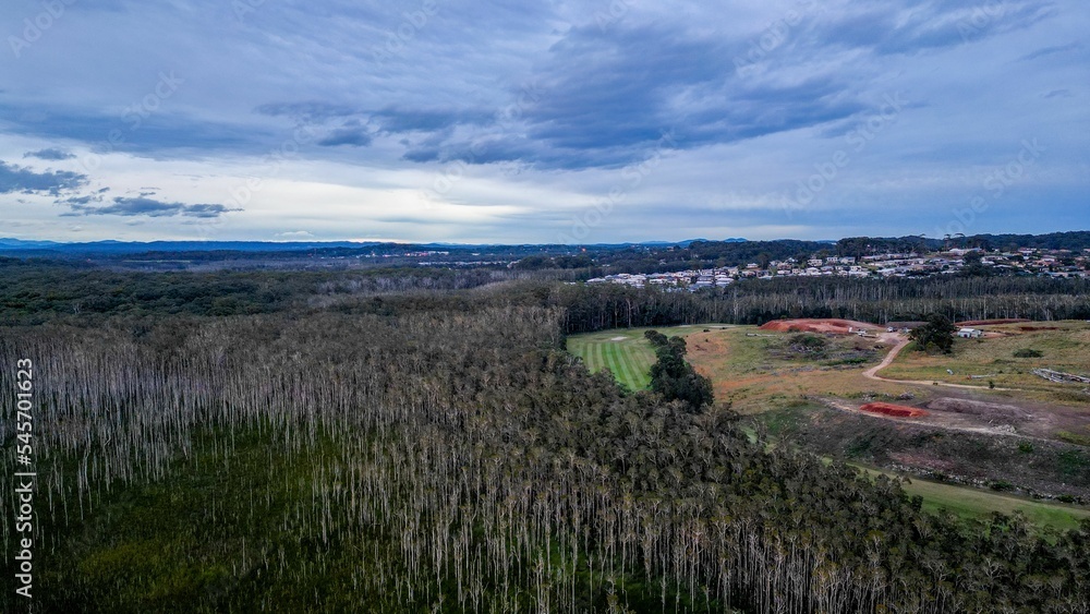Aerial shot of the Port Macquarie town with surrounding forest under the cloudy sky in Australia Aerial shot of the Port Macquarie town with surrounding forest under the cloudy sky in Australia