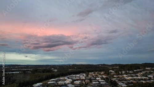 Aerial shot of the Port Macquarie town with surrounding forest at sunset in Australia