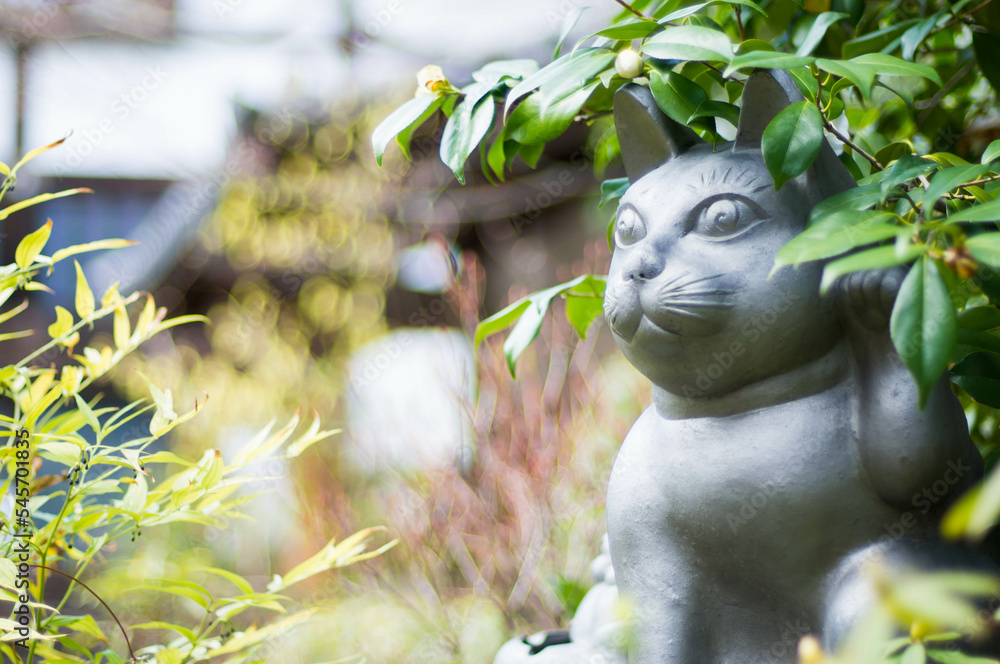 Obraz premium 京都 妙心寺の茂みの中に潜む猫の銅像