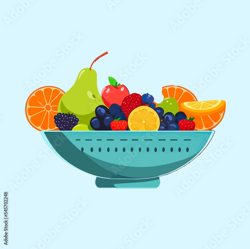 Bowl of fresh fruits on blue background