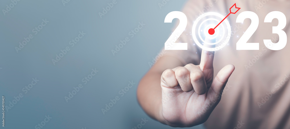 Target and goal of 2023. New year start success plan and vision. Hand touch target arrow 2023 icon in dark tone. Target and goal of 2023. New year start success plan and vision. Hand touch target arrow 2023 icon in dark tone.