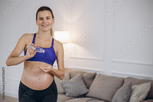 Pregnant woman using stretch mark oil