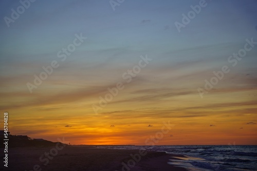 Breathtaking view of a sunset sky over a sandy beach and sea in Saint George Island, Florida