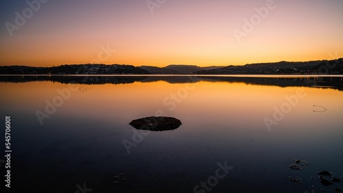 Beautiful sea view at sunset under a beautiful orange sky in Plimmerton, New Zealand photo