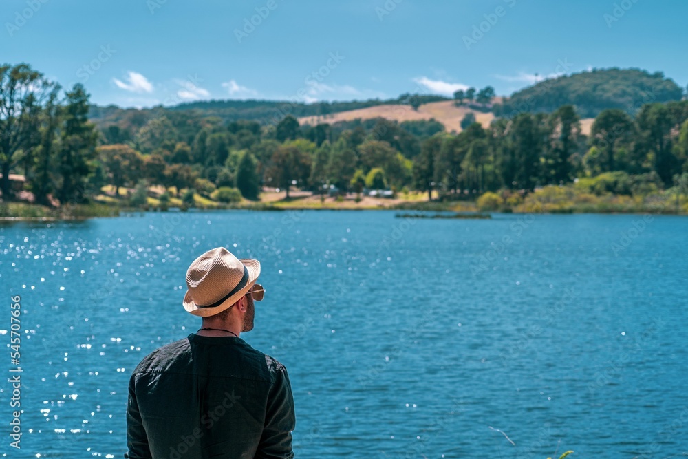Cool male tourists looking on a calm lake during a sunny day