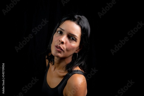 Caucasian young woman looking at camera against simple studio black background